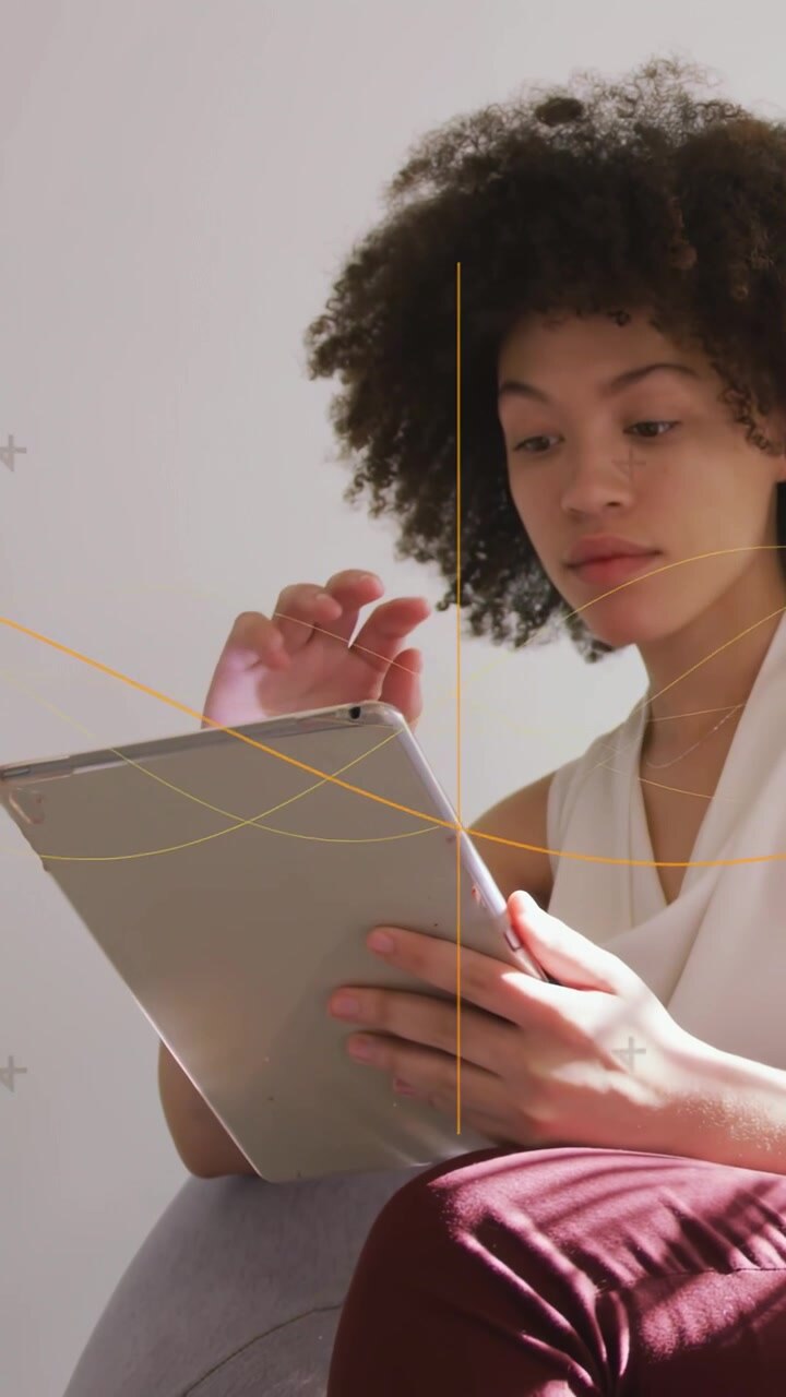 Vertical video: Woman tapping tablet in home causing graphic lines highlighting content for edtech