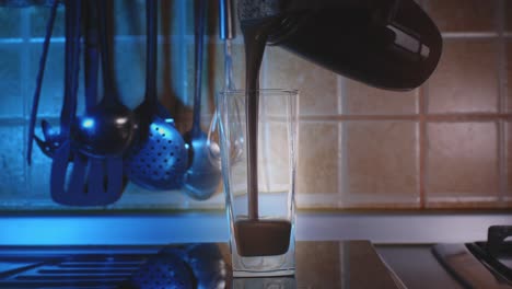 pouring chocolate banana protein smoothie into glass