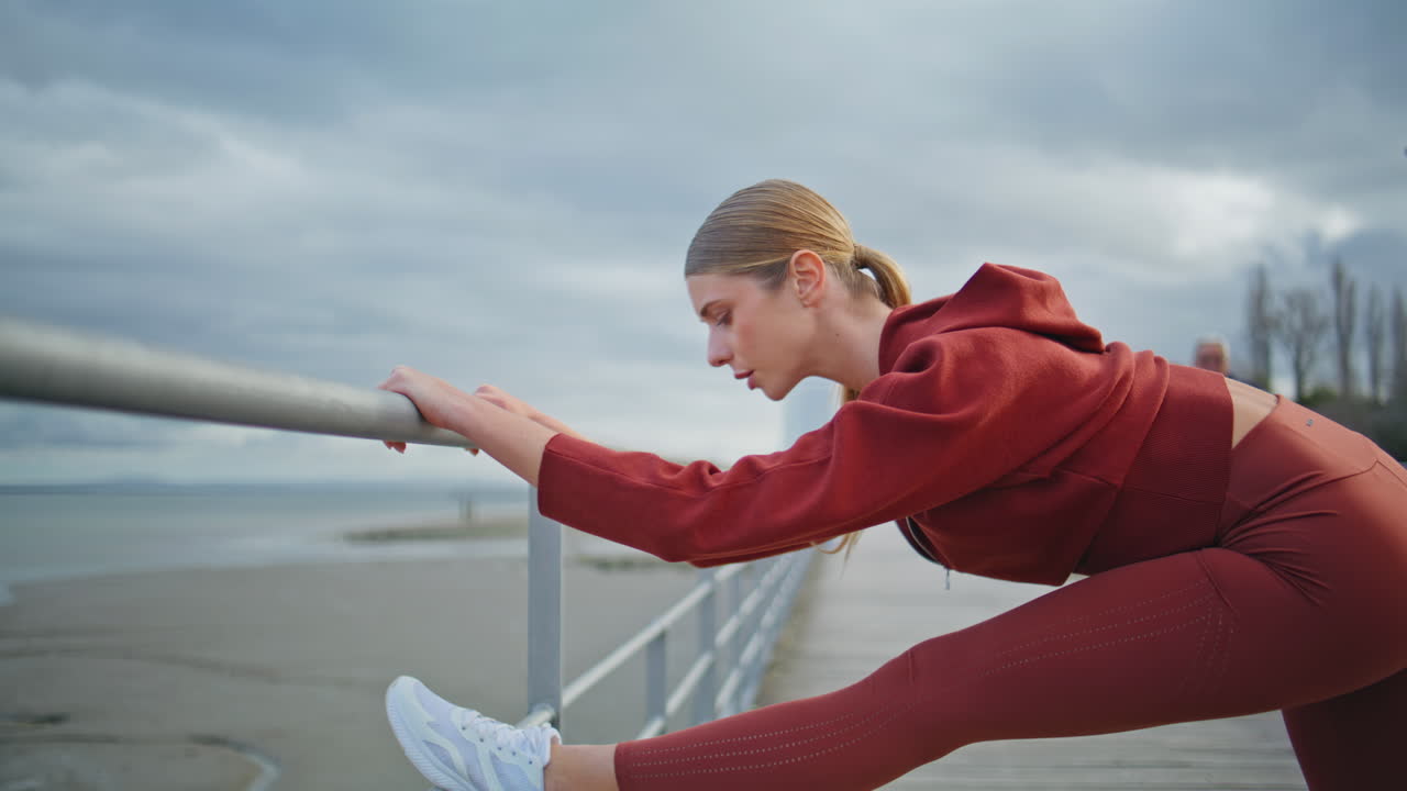Fitness woman workout outdoors at cloudy coast. Closeup motivated athlete bend