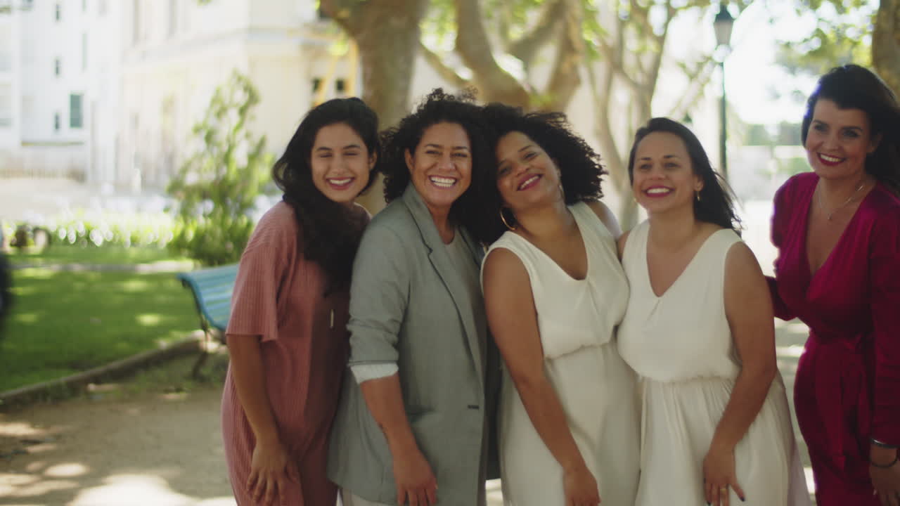 공원에서 친구들과 레즈비언 신혼 부부의 사진을 찍는 사진 작가의 뒷모습