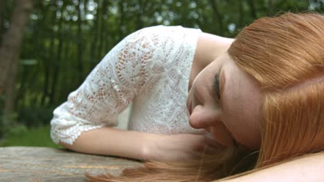 beautiful blonde woman wearing white dress feel sad on the forest alone - close up shot