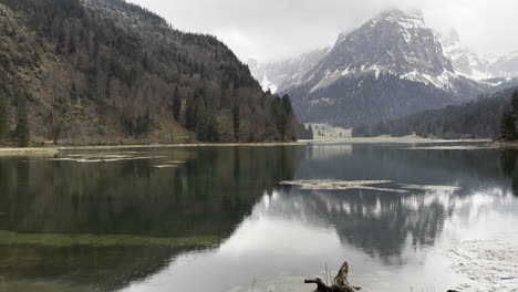 vista estática de un lago alpino transparente bajo la lluvia