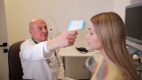 el médico comprueba la temperatura del paciente
