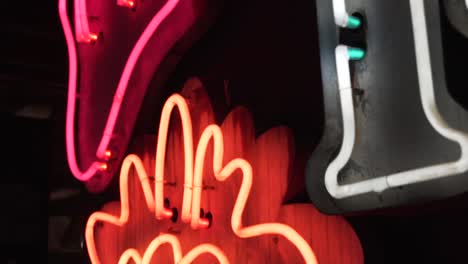 Pink-and-orange-neon-signsin-a-dark-room-in-slow-motion