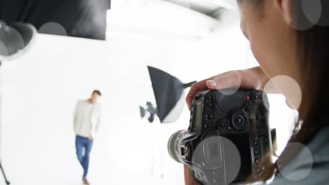 animation of white dots over caucasian female photographer and male model taking photos