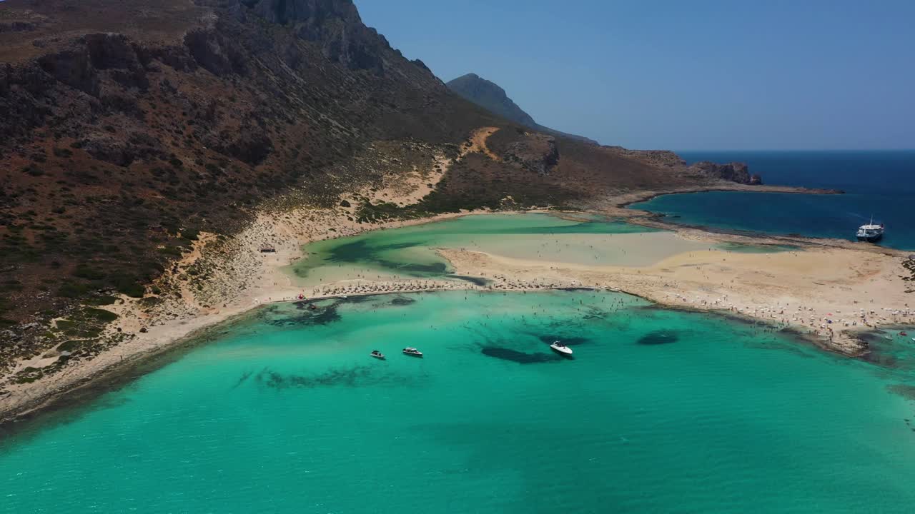 Aerial descending over Balos Beach and Lagoon with turquoise water, mountains and cliffs in Crete, Greece