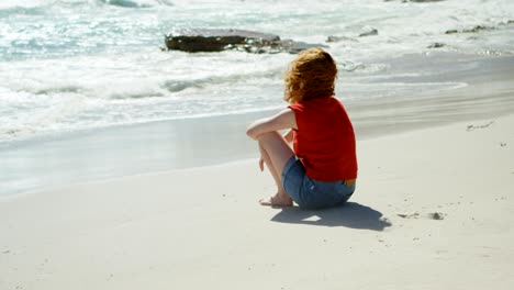 woman sitting on sand and looking at sea 4k