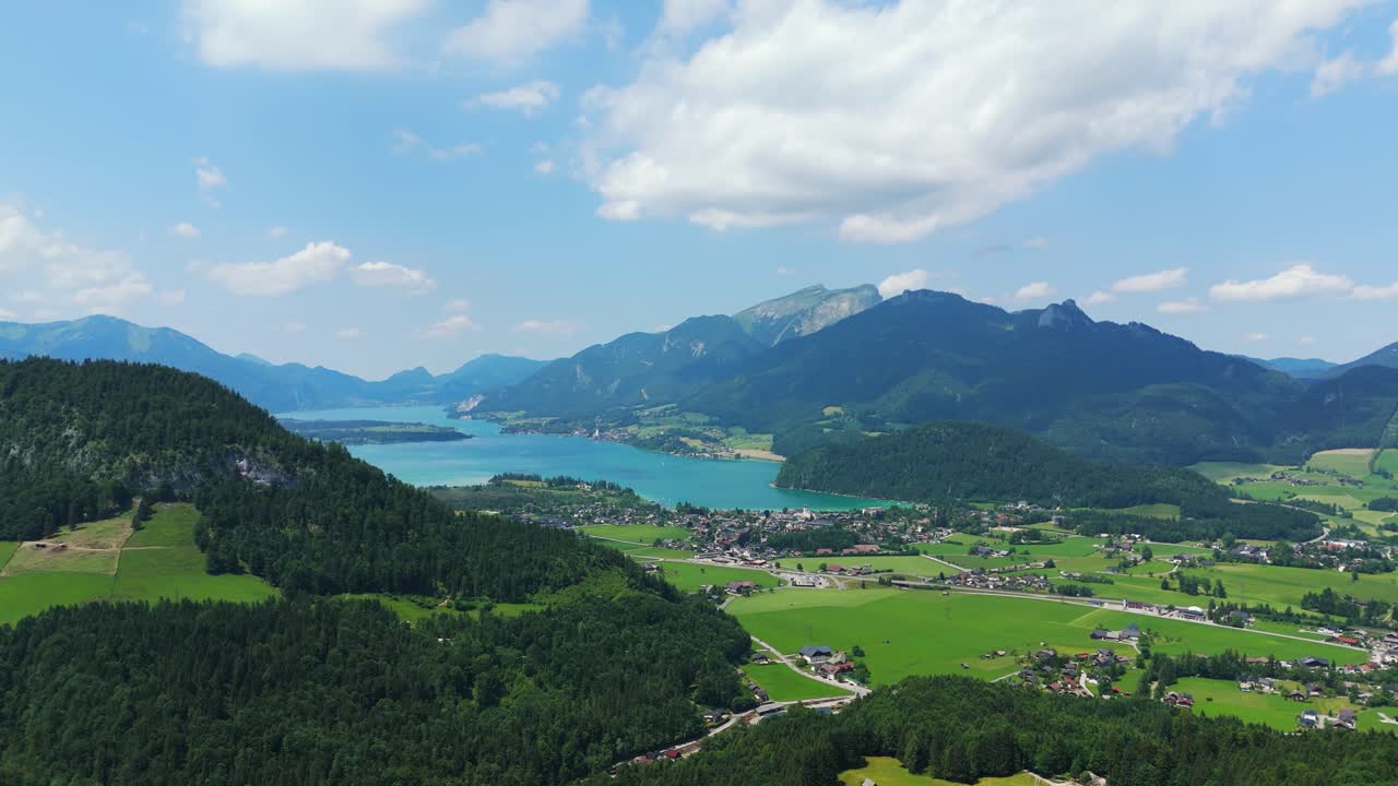 Ripresa drone della città di Strobl e del lago Wolfgangsee, circondati da splendide vette alpine austriache, con inquadratura d'apertura.