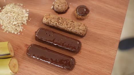 healthy homemade snack bars on wooden table, top down in slow motion