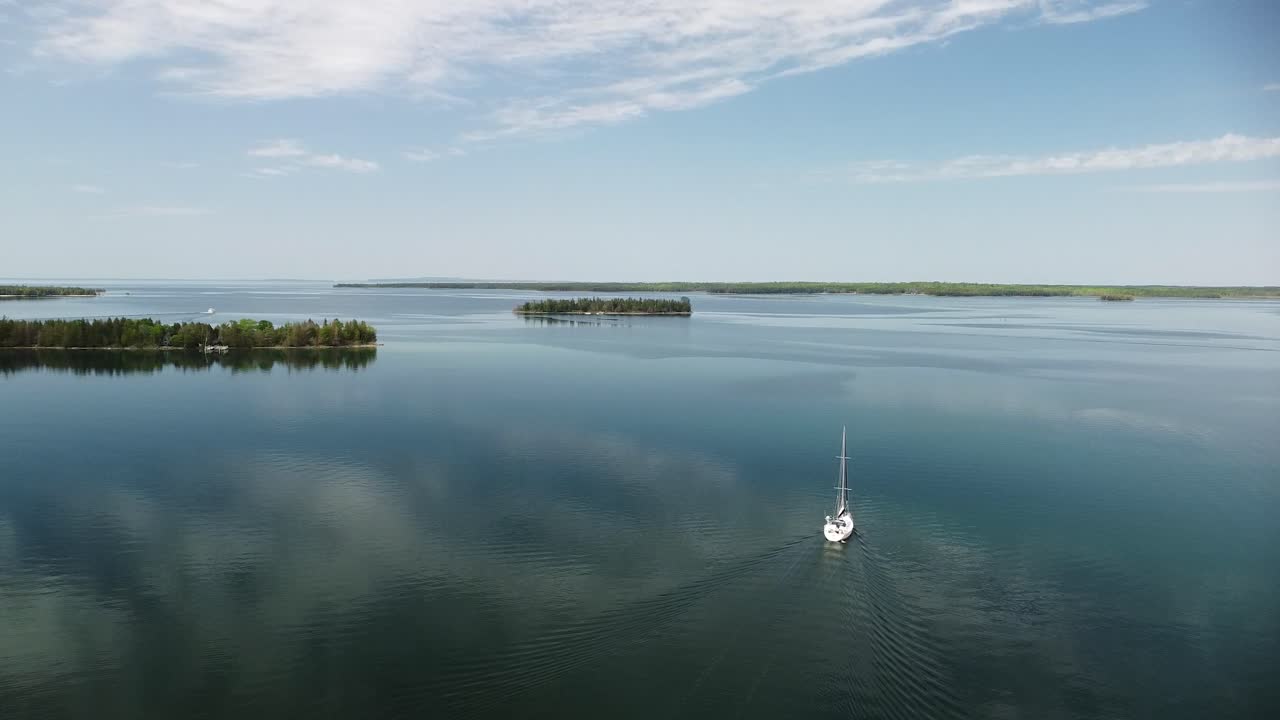 órbita aérea de velero en aguas tranquilas, islas les cheneaux, hessel, michigan