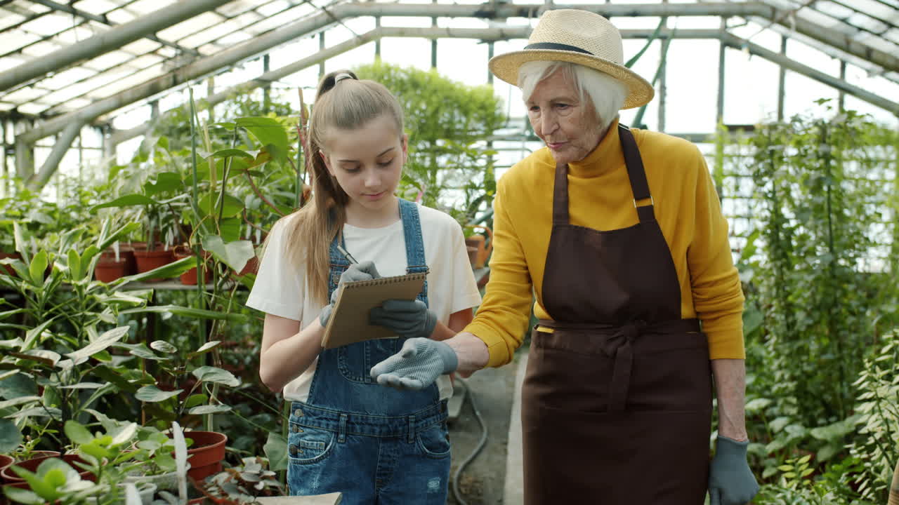 Grandmother and Granddaughter Working in a Greenhouse