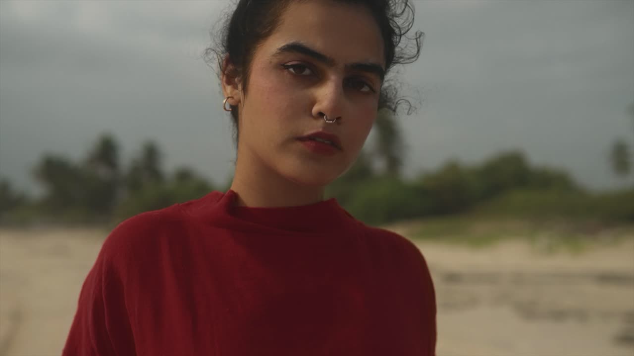 modelo de moda de cerca mirando a la cámara y posando en la playa de goa del mar arábigo