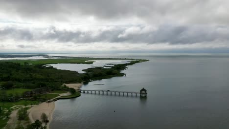 muelle de la playa de fontainebleau en la cuenca del lago pontchartrain, mandeville, louisiana en un día nublado - toma aérea de drones