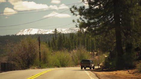 Blick-Auf-Ein-Schwarzes-Auto,-Das-In-Richtung-Eines-Angenehmen-Tals-In-Kalifornien,-USA,-Fährt,-Um-Verschiedene-Outdoor-Aktivitäten-Wie-Nahrungssuche,-Kochen,-Schießen,-Fahren-Und-Angeln-Durchzuführen