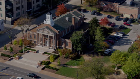 Overhead-view-of-street-in-small-town-with-a-tilt-up-to-reveal-city-hall-on-a-pretty-Autumn-day