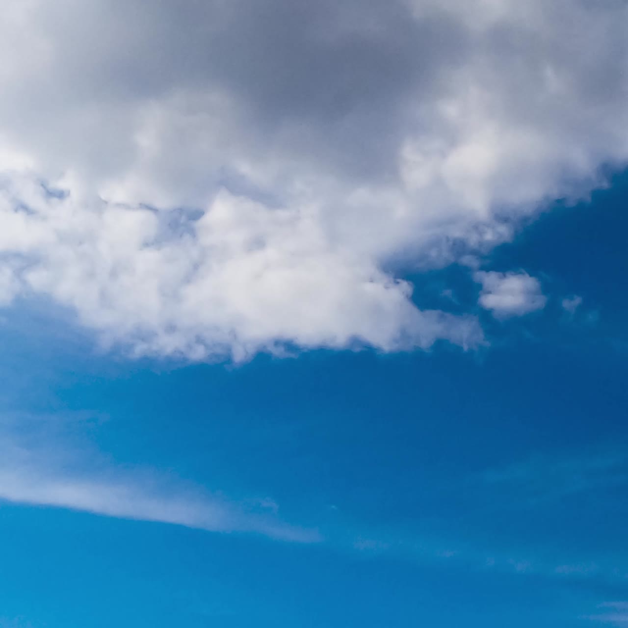 Blue sky with cumulus clouds moving quickly. Rainy cloudscape formation. Low angle view. Timelapse. Vertical screen