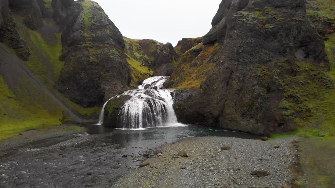cascada de agua de stjornarfoss que fluye sobre las rocas en el desfiladero de musgo