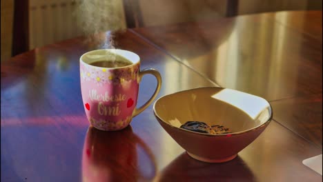 steaming cup of coffee and cookies in bowl