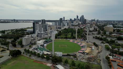 Vista-Aérea-Cinematográfica-Del-Estadio-Deportivo-De-Cricket-Waca-En-Perth-Con-La-Vista-De-Los-Edificios-Del-Horizonte-En-El-Fondo-Del-Río-Swan,-Australia-Occidental