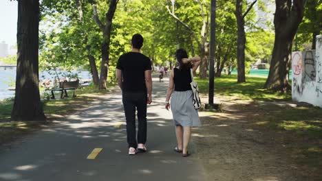 rear view of couple walking along path by park