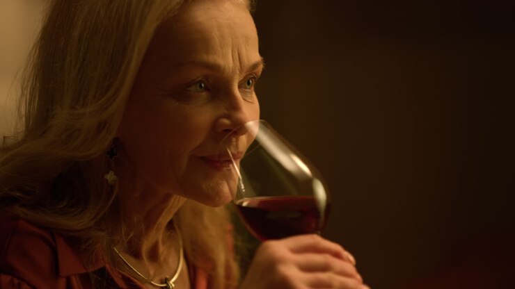 Old aged woman drinking red wine glass indoor