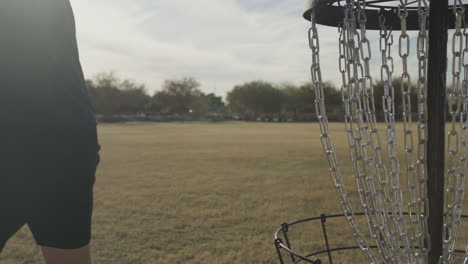 man smashes disc into cage of disc golf basket in frustration of missing a shot | disc golf meltdown