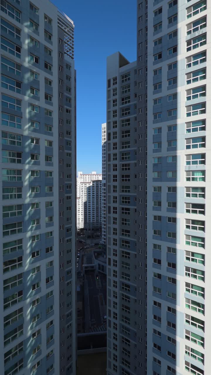 Ripresa verticale con drone che ruota verso destra per rivelare un fitto gruppo di imponenti grattacieli residenziali moderni e complessi di appartamenti nel centro di Daegu, Corea del Sud.