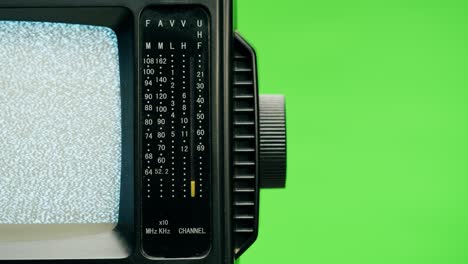 pequeño televisor con pantalla de interferencia gris sobre fondo verde cromado. primer plano de televisión antigua, nostalgia. pantalla de ruido gris y fallos