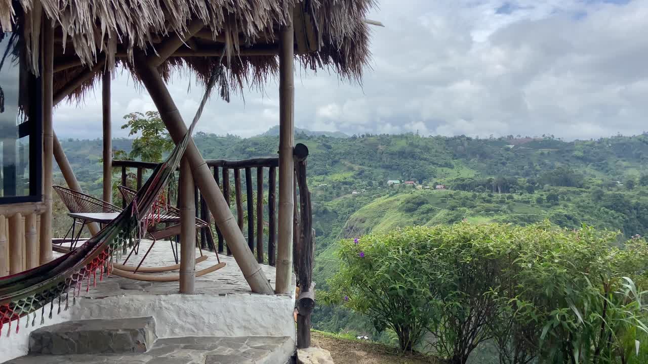balcón de una suite de cabaña con una hamaca colgando con vistas a la selva colombiana