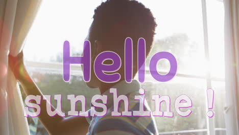 animation of hello sunshine text in purple over african american boy drawing curtains on sunny day