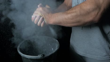 weightlifter applying chalk to hands