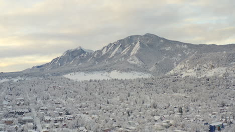 Disparo-De-Un-Dron-Alto-Y-Ancho-Que-Avanza-Hacia-Boulder-Colorado-Y-Las-Montañas-Rocosas-Flatiron-Después-De-Que-Una-Gran-Tormenta-De-Nieve-Invernal-Cubre-árboles,-Casas,-Calles-Y-Vecindarios-En-Nieve-Blanca-Fresca