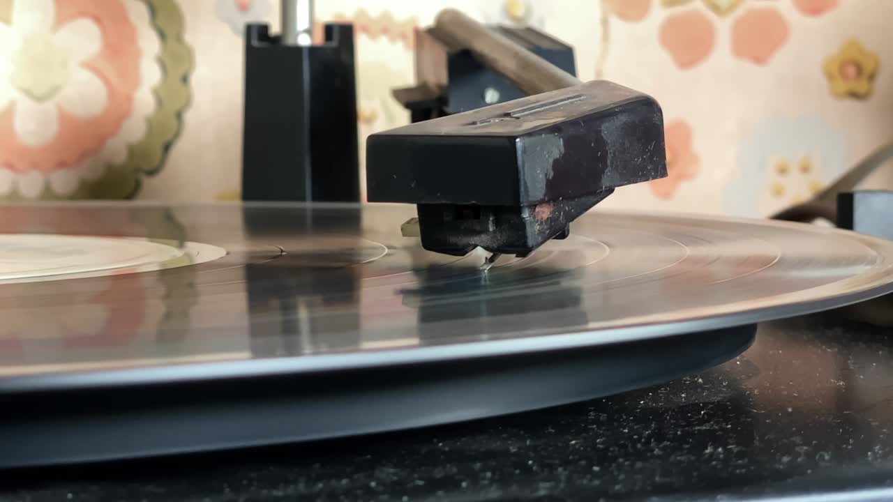 검은 비닐 레코드의 트랙을 재생하는 턴테이블의 바늘.