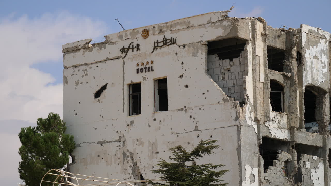 Primo piano che mostra i danni da artiglieria a un hotel quasi completamente distrutto alla periferia di Homs, Siria