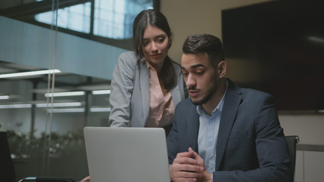 Business Professionals Collaborating on Laptop in Modern Office