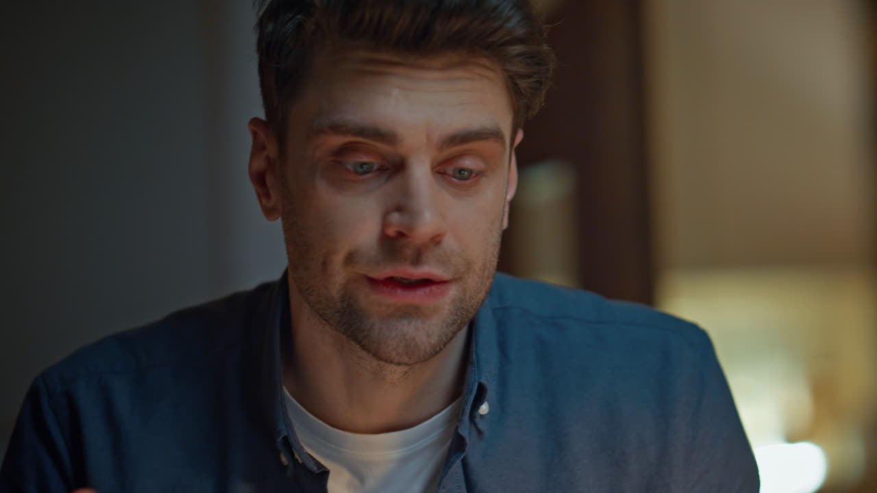 Worried freelancer talking online late at home closeup. Nervous man video call