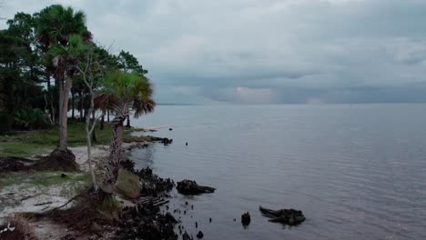 Aerial-flying-by-a-bay-beach-and-palm-trees-towards-Apalachicola-Bay-in-Florida