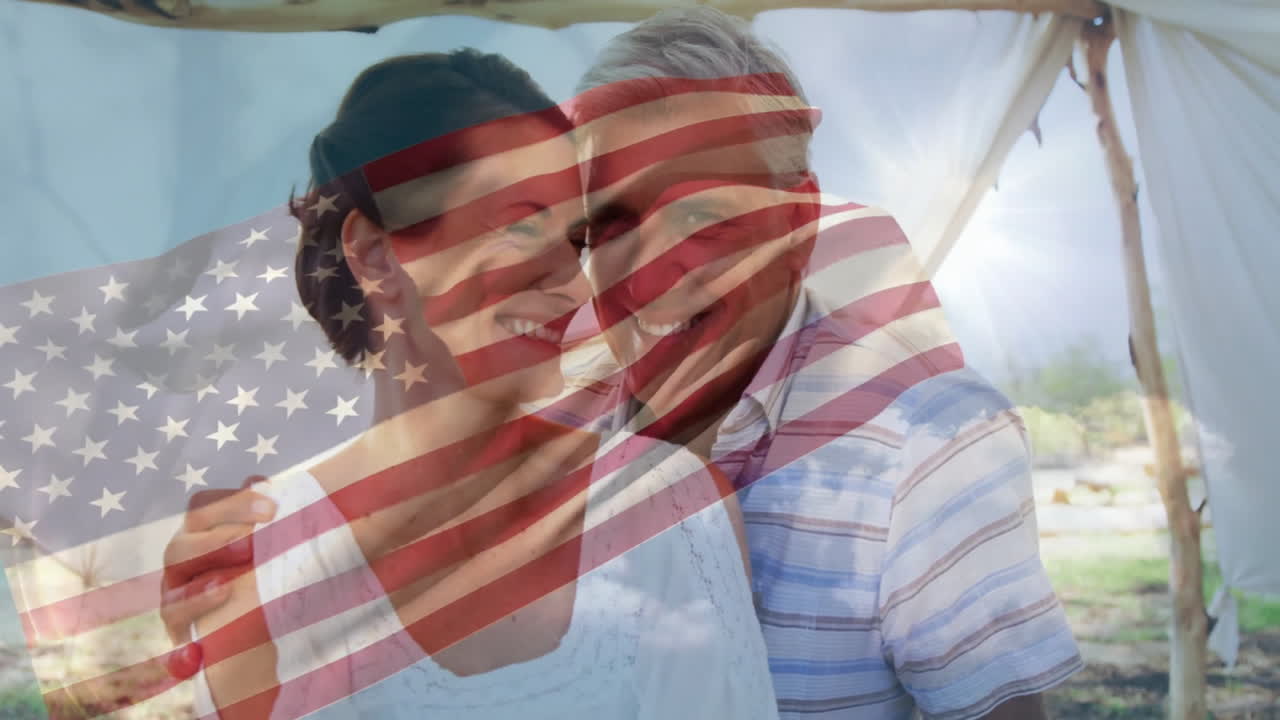 Embracing couple with American flag animation overlay outdoors, smiling together