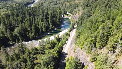 Un-Dron-Aéreo-Captura-Una-Pintoresca-Carretera-Montañosa-Y-Un-Sendero-Cerca-Del-Río-Stillaguamish-En-Verlot,-Washington