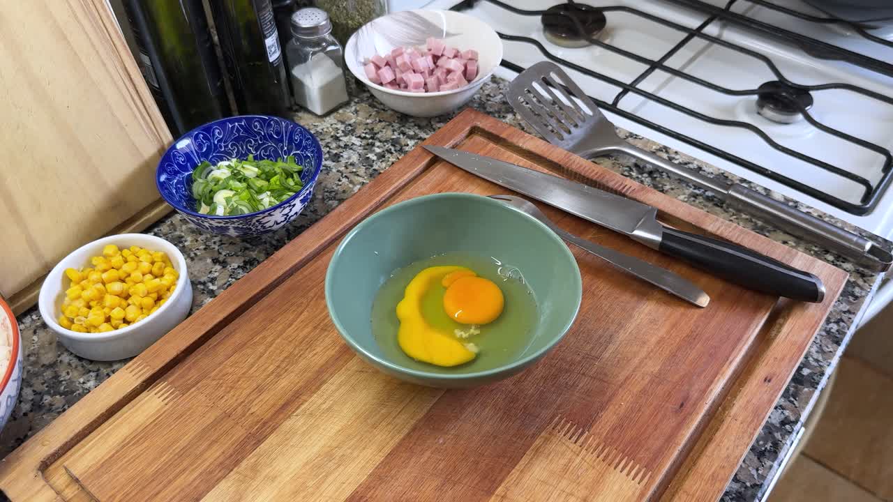 Person Beating Eggs With A Fork In A Bowl. High Angle Shot