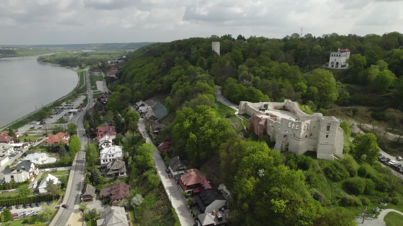 vista aérea hacia atrás del hermoso castillo de kazimierz en una colina entre árboles verdes