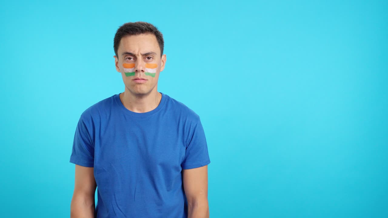 Man standing with indian flag painted on face smiling