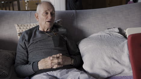 Elderly man sitting on a couch