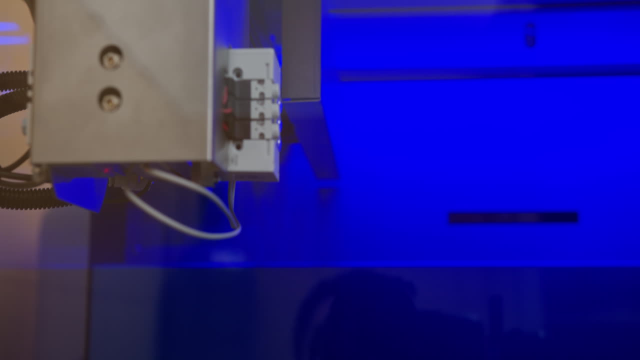 Close-up view of industrial machine components under blue light