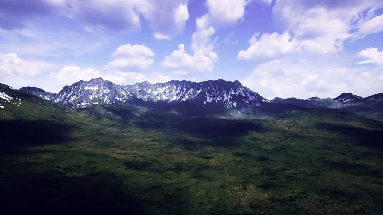 Majestic mountain range under a sunny sky with scattered clouds