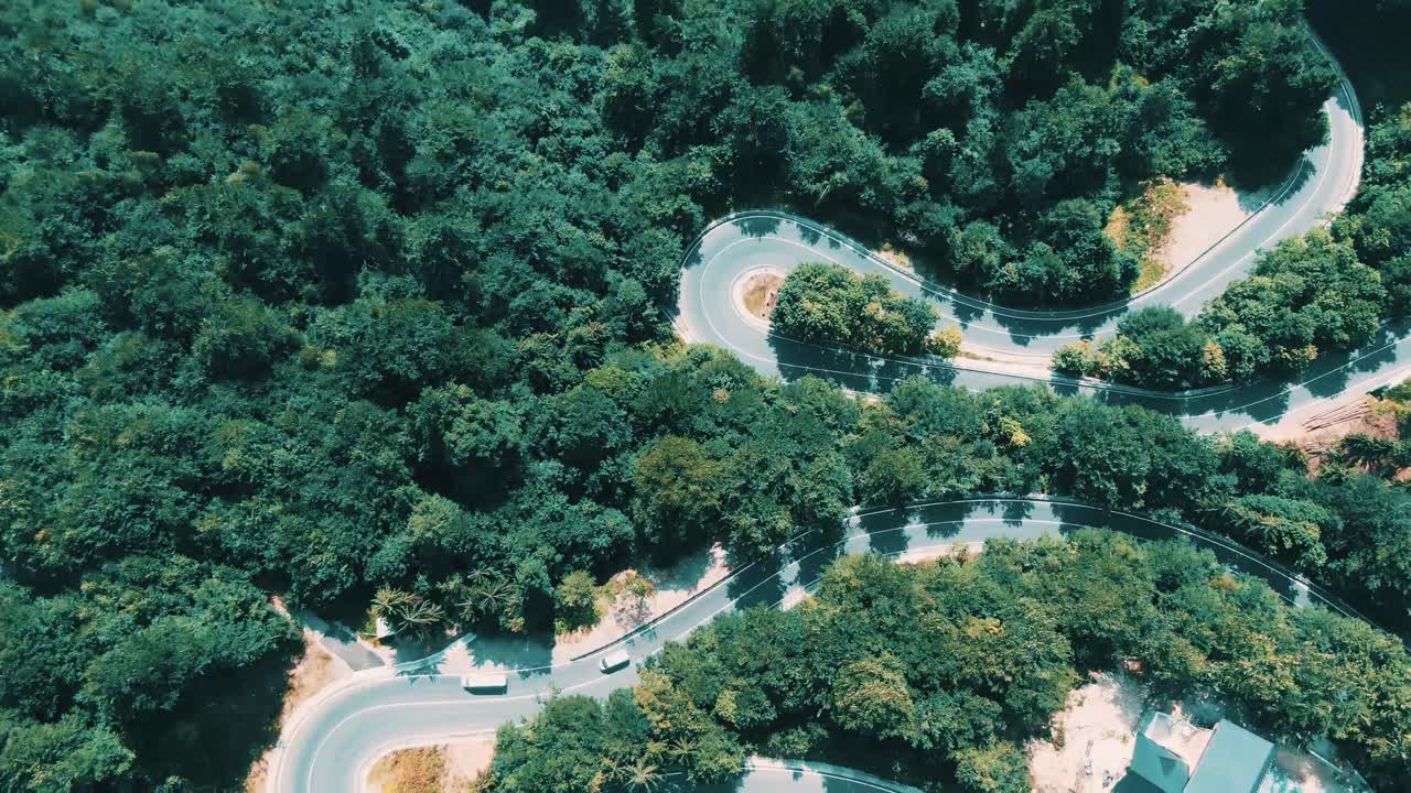 구불구불한 산비탈 길을 달리는 자동차를 4K 항공 촬영한 영상