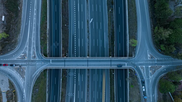 Hyper lapse aerial view looking down at busy highway traffic intersection, vehicles moving at speed