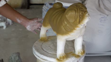 woman hand in glove paint pug dog statue details by airbrush