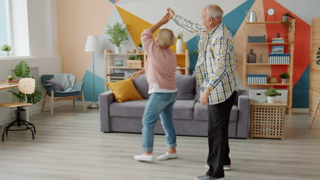 una pareja feliz bailando en casa.