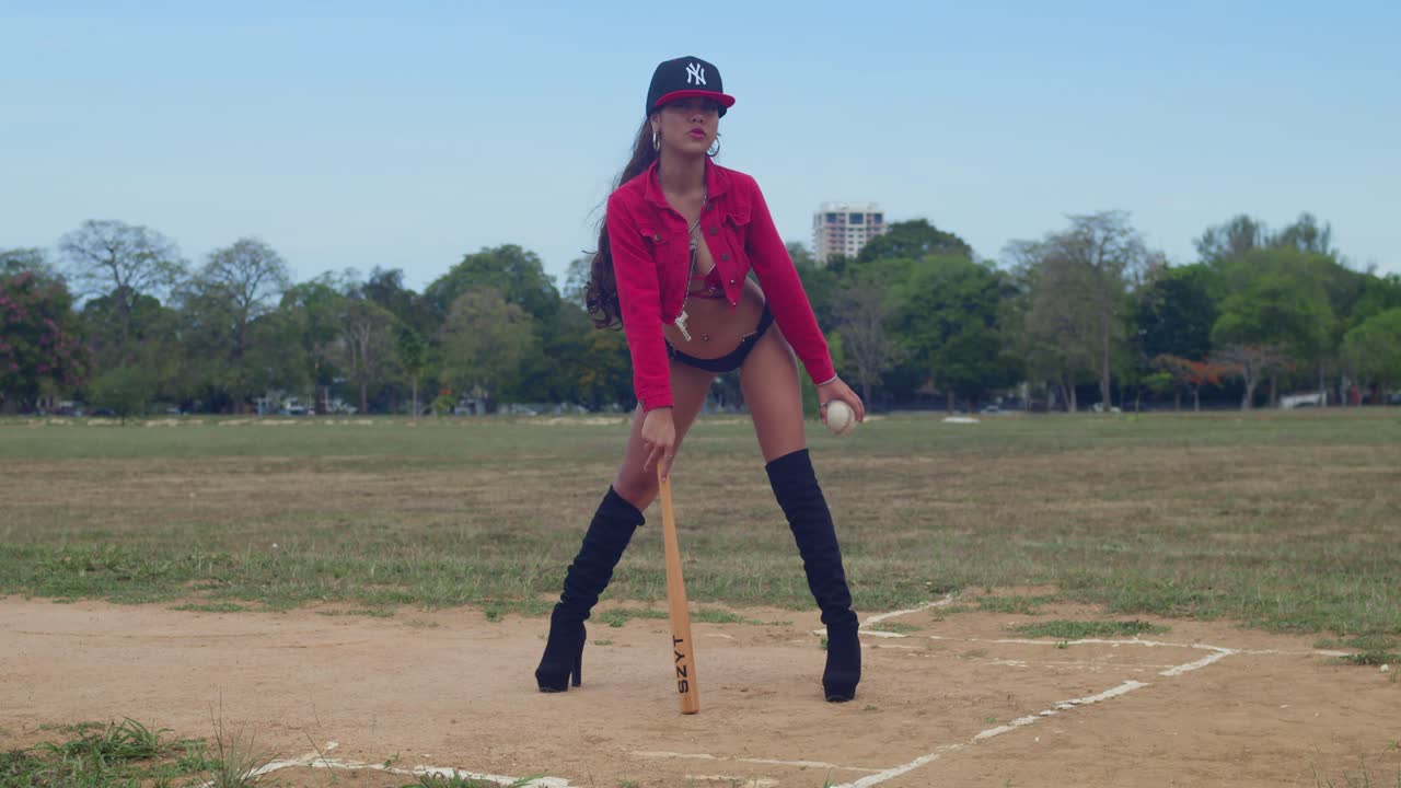 una chica con un traje de bikini de béisbol en un campo exuberante en la vibrante isla de trinidad